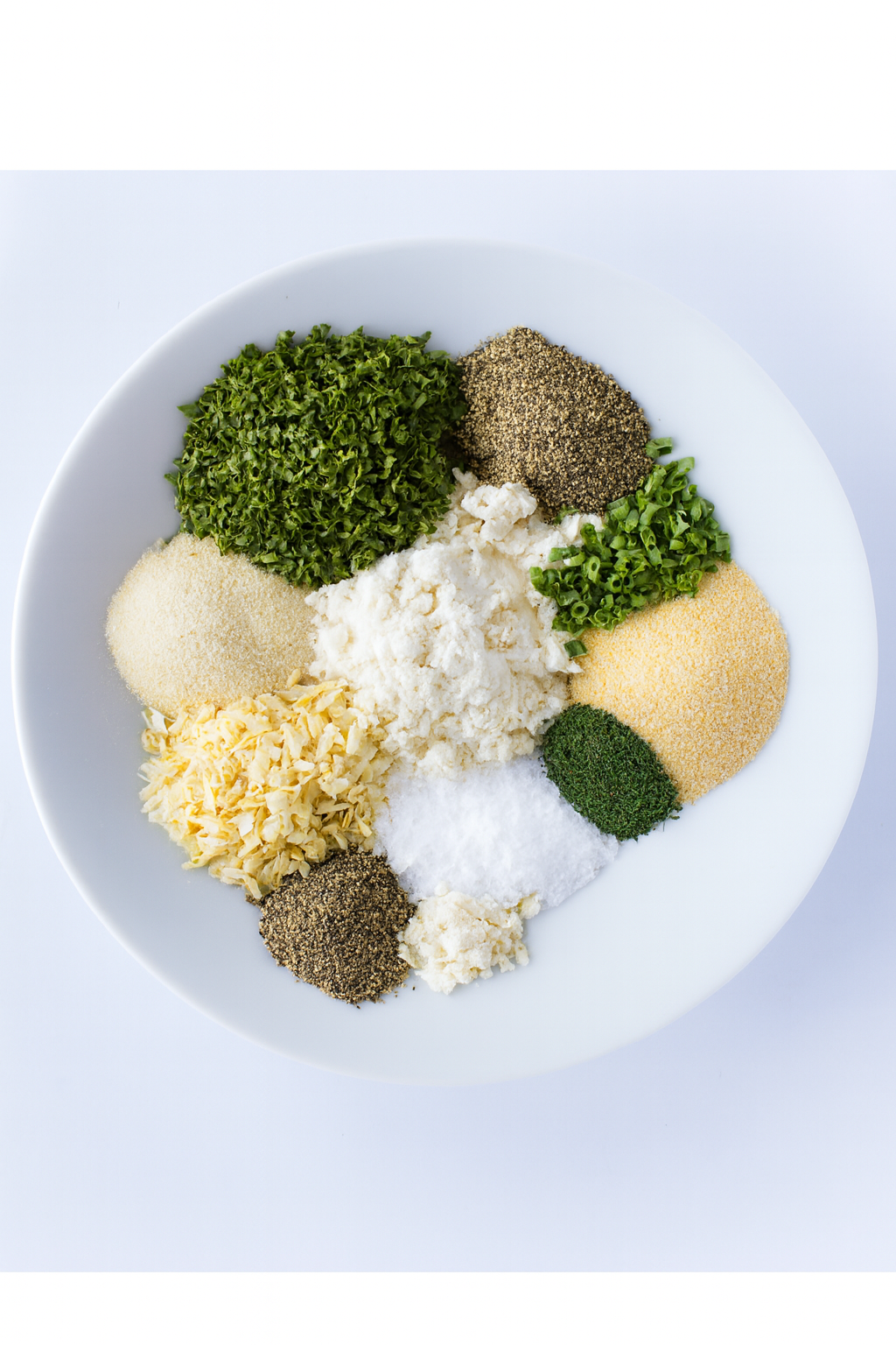 Assorted spices and herbs on a white plate